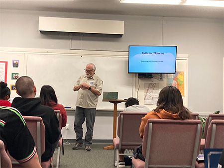 Photo of teacher presenting in classroom with students at the Science & Faith Workshop event